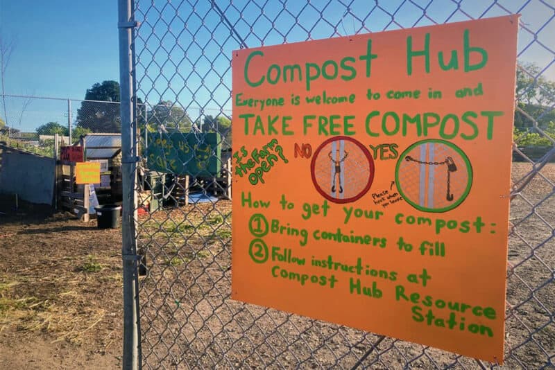 Alameda Post - a colorful poster on a chain link fence listing out details for the compost hub