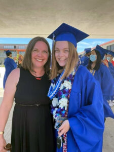 Alameda Post - a mother and daughter stand next to each other. The daughter wears graduation robes