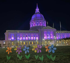 Alameda Post - San Francisco City Hall lit up in purple with flowers in front
