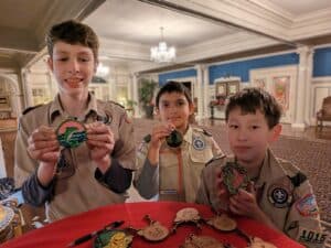 Alameda Post - three Scouts stand in their uniforms posing with laser-cut ornaments