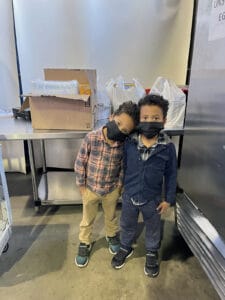 Alameda Post - two 5 year old kids pose by a large industrial fridge