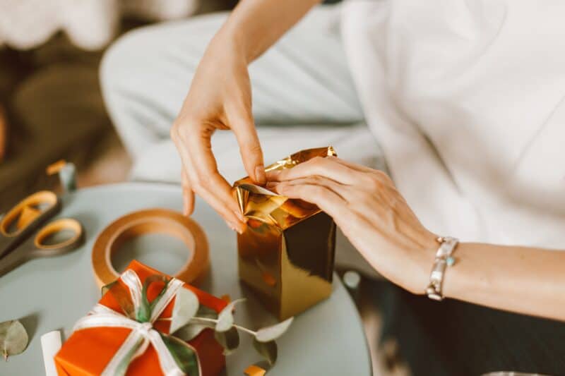 Alameda Post - Holiday gift guide. a pair of hands wrapping presents