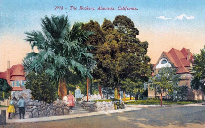 Alameda Post - an old color drawing of the Rockery. Children play and explore in a small triangular park with stone walls, grass, and trees