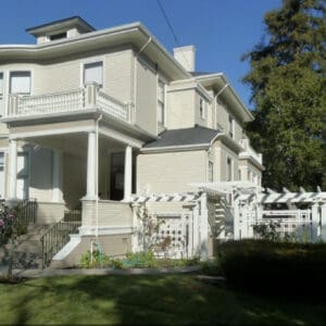 Alameda Post - a grand old house in shades of cream and white with a delicate fence