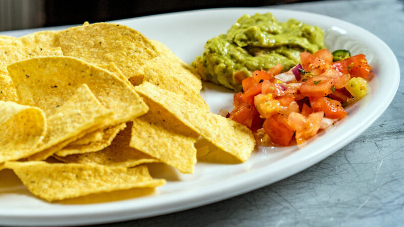 Alameda Post - a plate of tortilla chips with guacamole and salsa