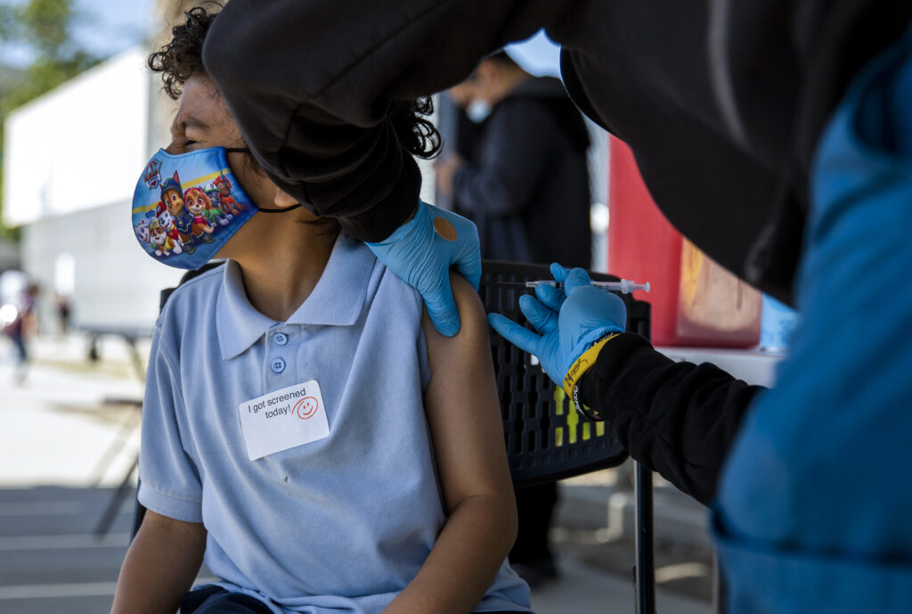 Alameda Post - Jayden Elizondo, 5, gets his Covid-19 vaccine at one of St. John’s Well Child and Family Center mobile health clinics set up outside Helen Keller Elementary School in Los Angeles on Wednesday afternoon, March 16, 2022. The clinic offers vaccines to students as well as community members in the neighborhood. St. John’s Well Child and Family Center clinics have administered around 450,000 Covid-19 vaccines in Los Angeles since the pandemic began. Photo by Alisha Jucevic for CalMatters