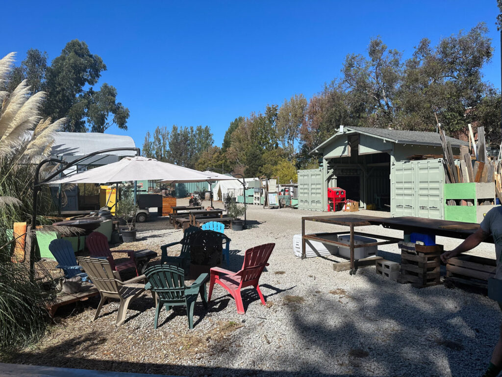 Alameda Post - the outdoor view of the REAP Climate Center, including beach chairs and umbrellas and buildings 