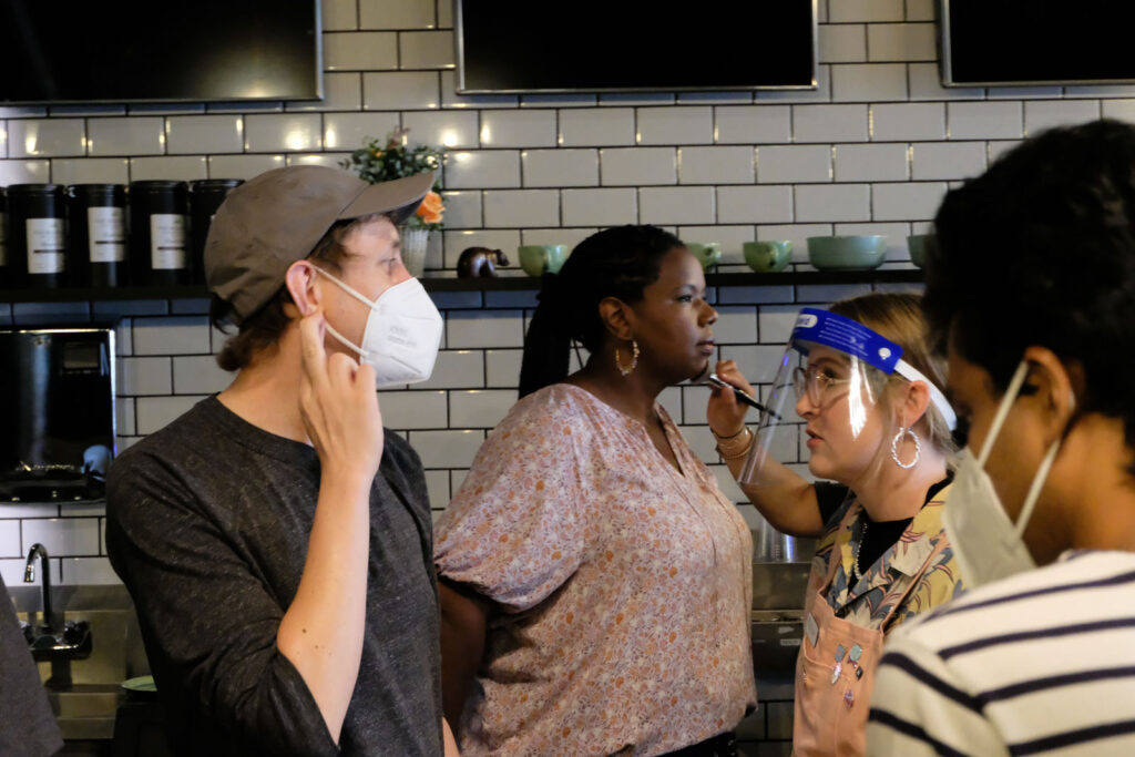 Alameda Post - a cast member on a movie set gets their makeup done