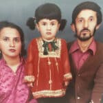 Alameda Post - a family of three in a formal portrait. The little toddler wears pigtails in her hair