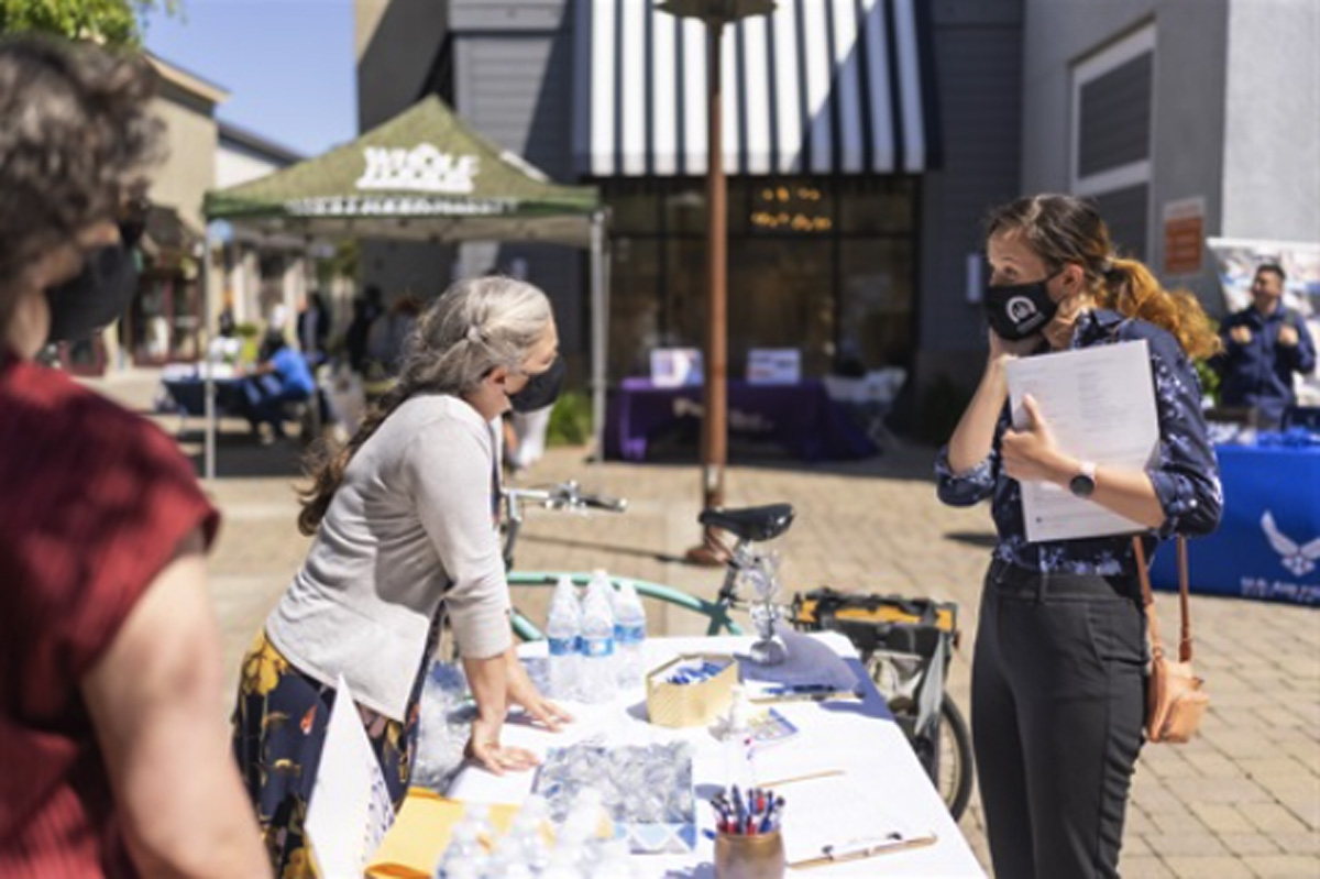 Alameda Post - a person goes to a job fair booth