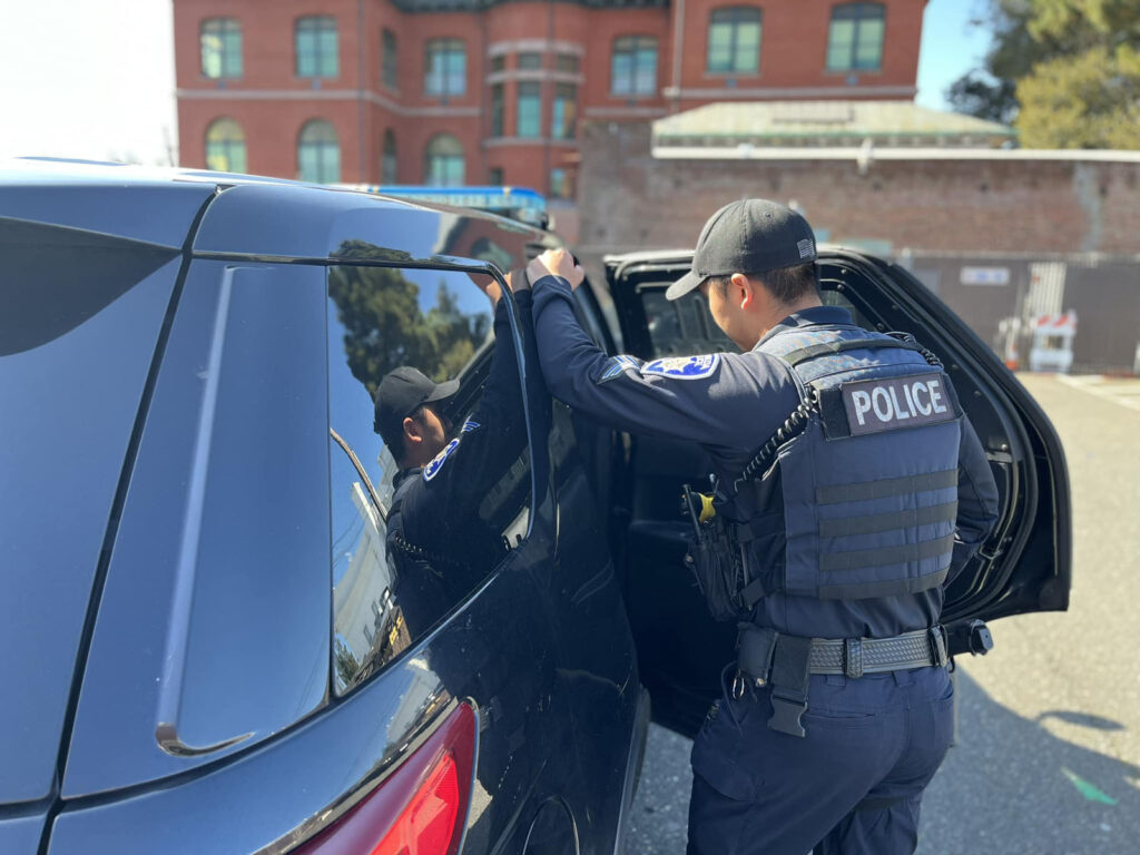 Alameda Post - an APD officer stands outside of a stolen vehicle