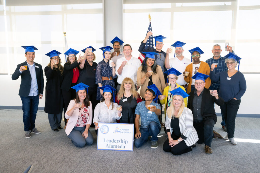 Alameda Post - a group photo of adults in graduation caps around a sign that says Leadership Alameda