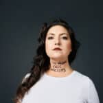 Alameda Post - a photo of Chelsea Hollow. On her throat is written "This machine kills fascists."
