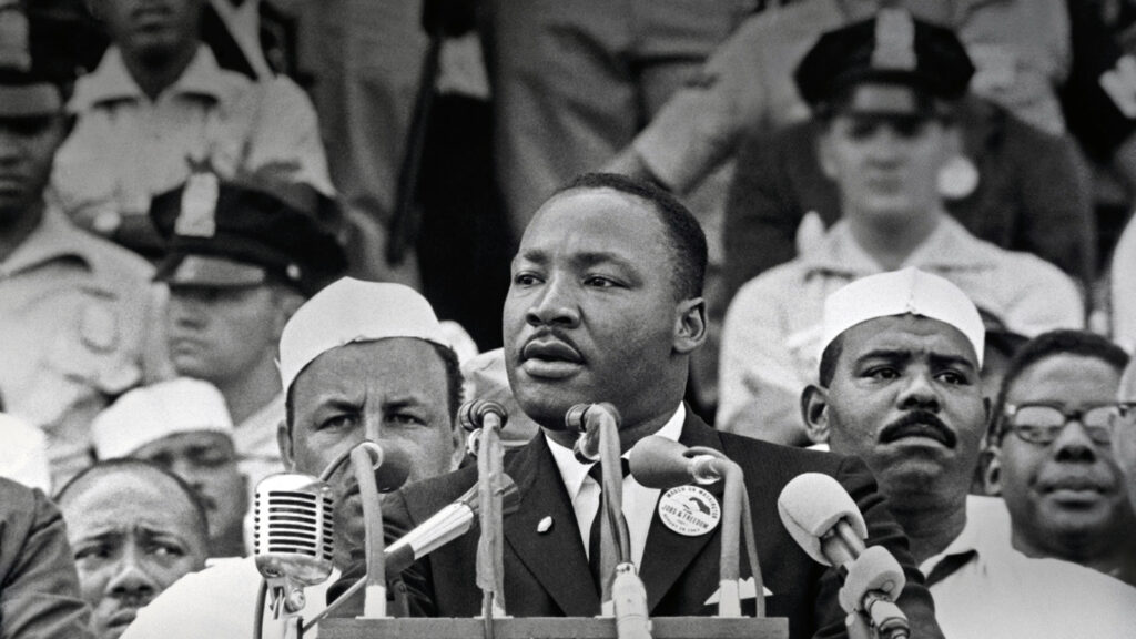 Alameda Post - Martin Luther King Jr. giving a speech behind a podium of microphones