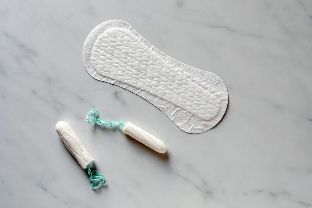 Alameda Post - menstrual supplies, including tampons and a maxi-pad on a marble background