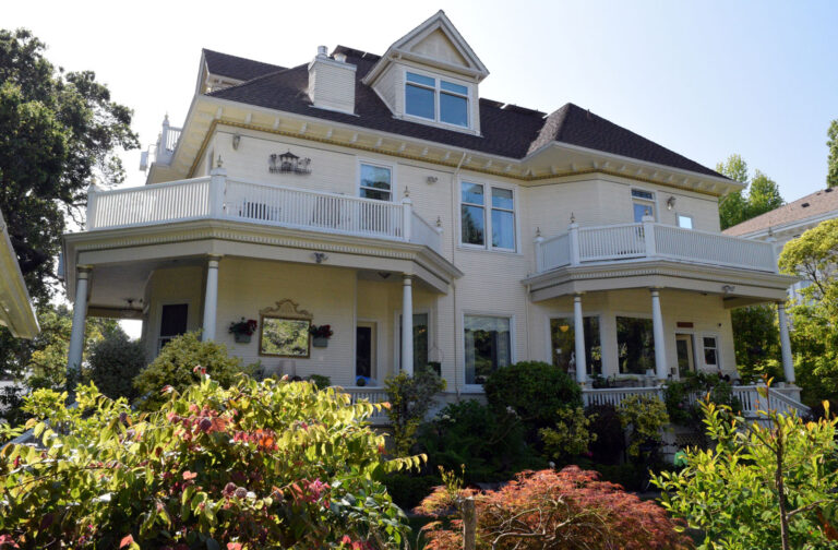 Alameda Post - the back of a grand house at 1240 St. Charles Street. It has multiple porches on the second story