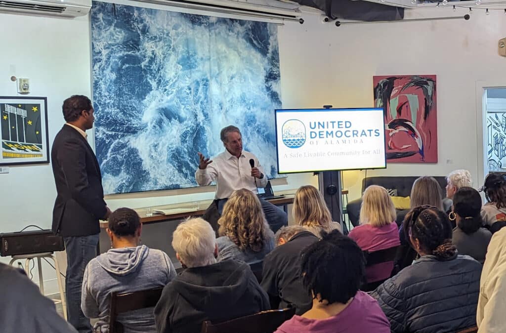 Alameda Post - United Democrats of Alameda meeting. People sit in a room and listen to a speaker