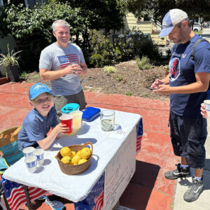 Alameda Post - a lemonade stand and a Alameda Post parade goer purchasing a glass