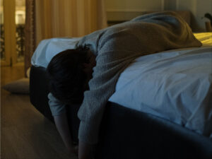 Alameda Post - a person lays face down on a bed