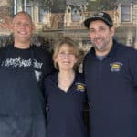 Alameda Post - two men and a woman stand in front of Domenico's Italian Deli wearing branded shirts