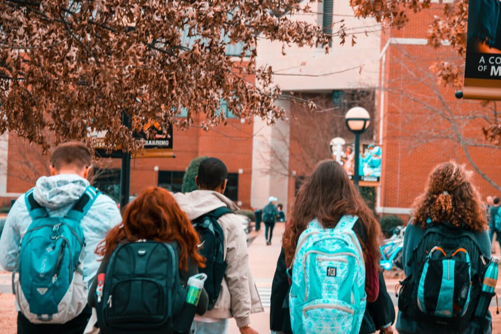Alameda Post - teens with backpacks walk towards a school
