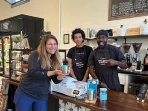 Alameda Post - a costumer stands by the coffee bar at Savoy Island Market and holds her OKAPI cup