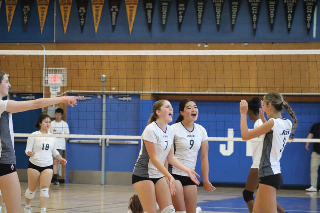 Alameda Post - teammates celebrate on a volleyball court