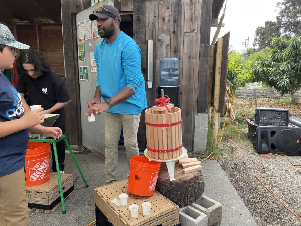 Alameda Post - volunteers at the Farm2Market Harvest Festival give out apple cider