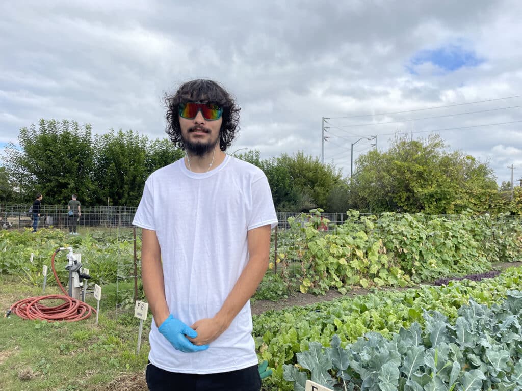 Alameda Post - Jason stands in front of the gardens at Alameda Point Collective farm