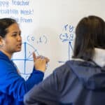 Alameda Post - a Saint Joseph Notre Dam High School student stands at the board with a marker doing math