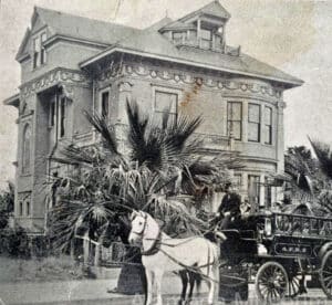 Alameda Post - a black and white photo of a horse drawn vehicle parked in front of a large mansion.