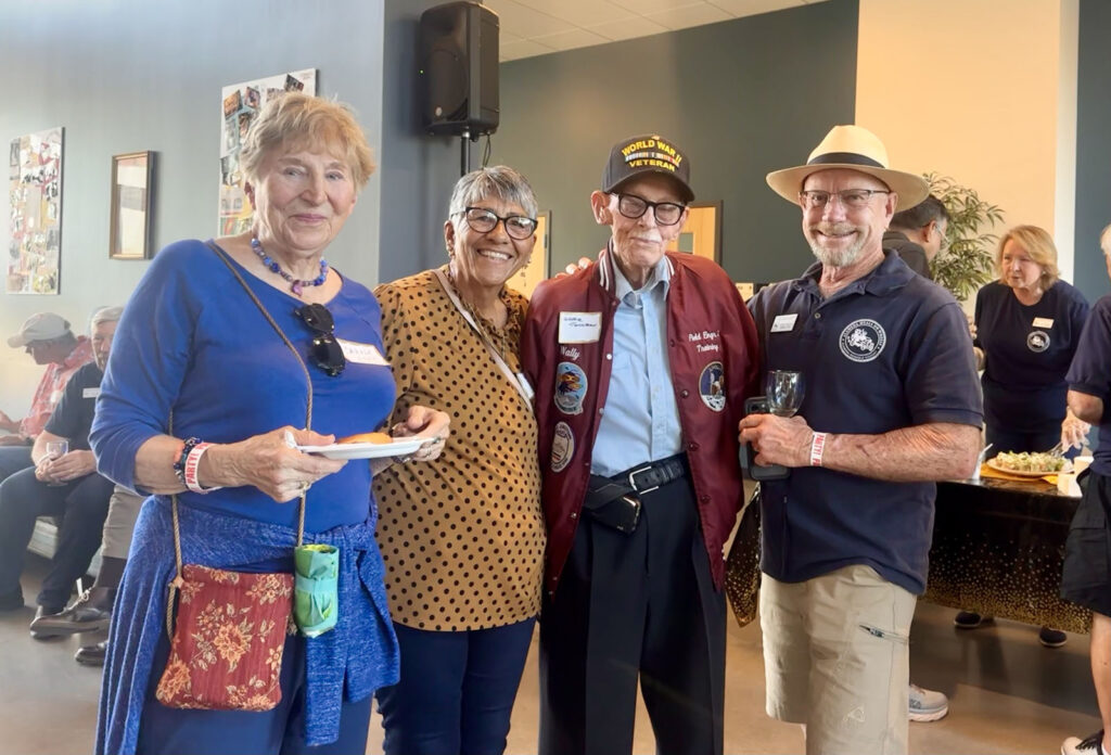 Alameda Post - four people pose together at the Meals on Wheels anniversary celebration