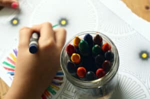 Alameda Post - a child's hand coloring with crayons