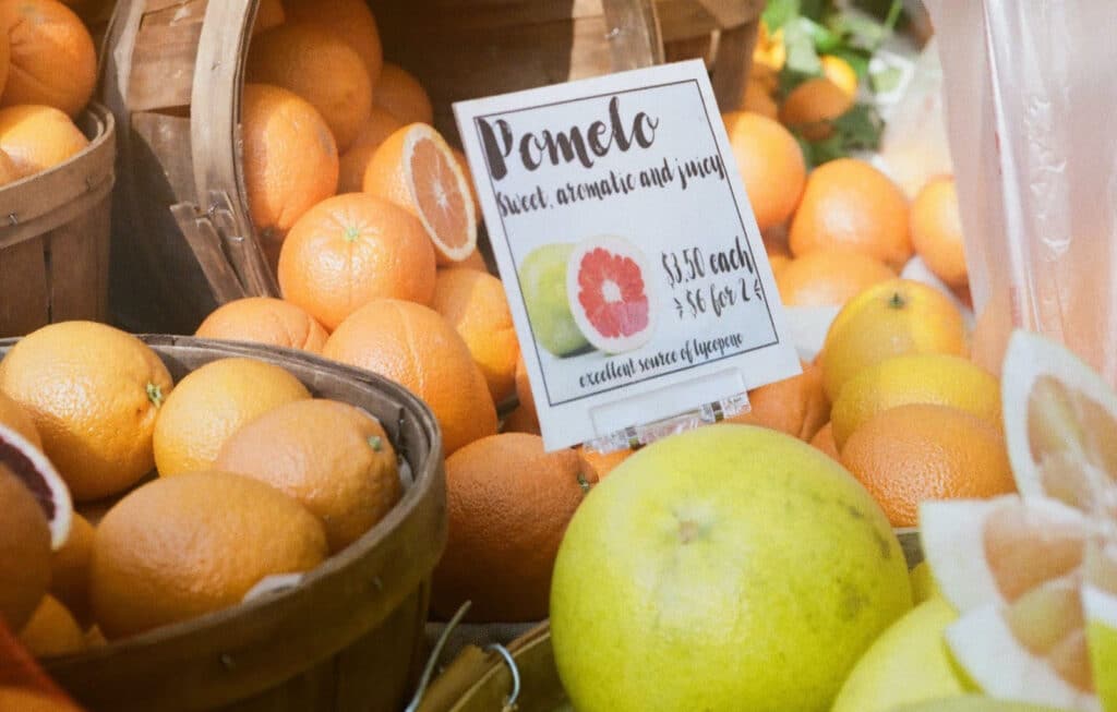 Alameda Post - pomelo among other citrus in baskets at a market
