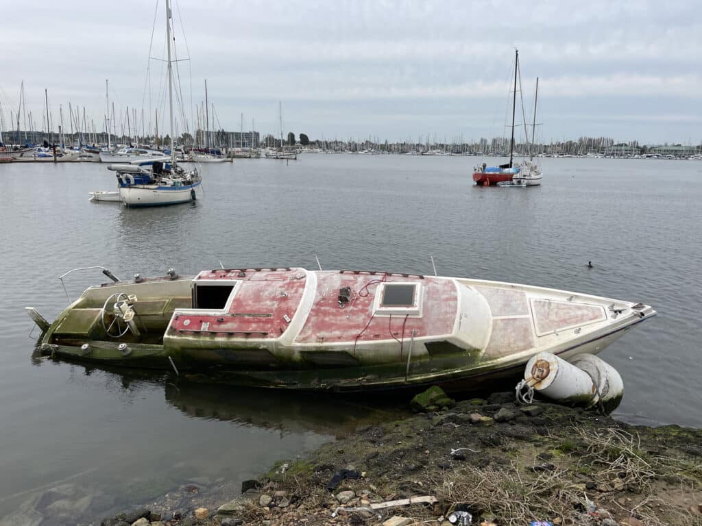Alameda Post - an abandoned vessel tipped over and leaning on the shoreline