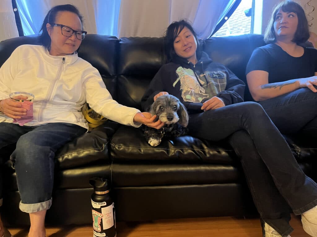 Alameda Post - three people sit with Gigi on the sofa