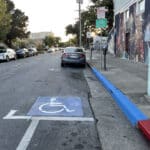 Alameda Post - a blue curbed disability parking space