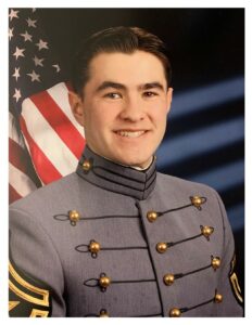 Alameda Post - A young man in a military uniform smiles in front of an American flag backdrop