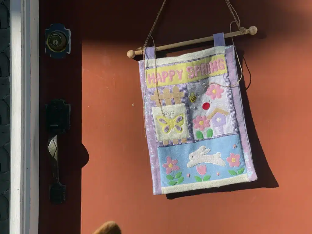 Alameda Post - a door with a festive "happy spring" sign hanging on it