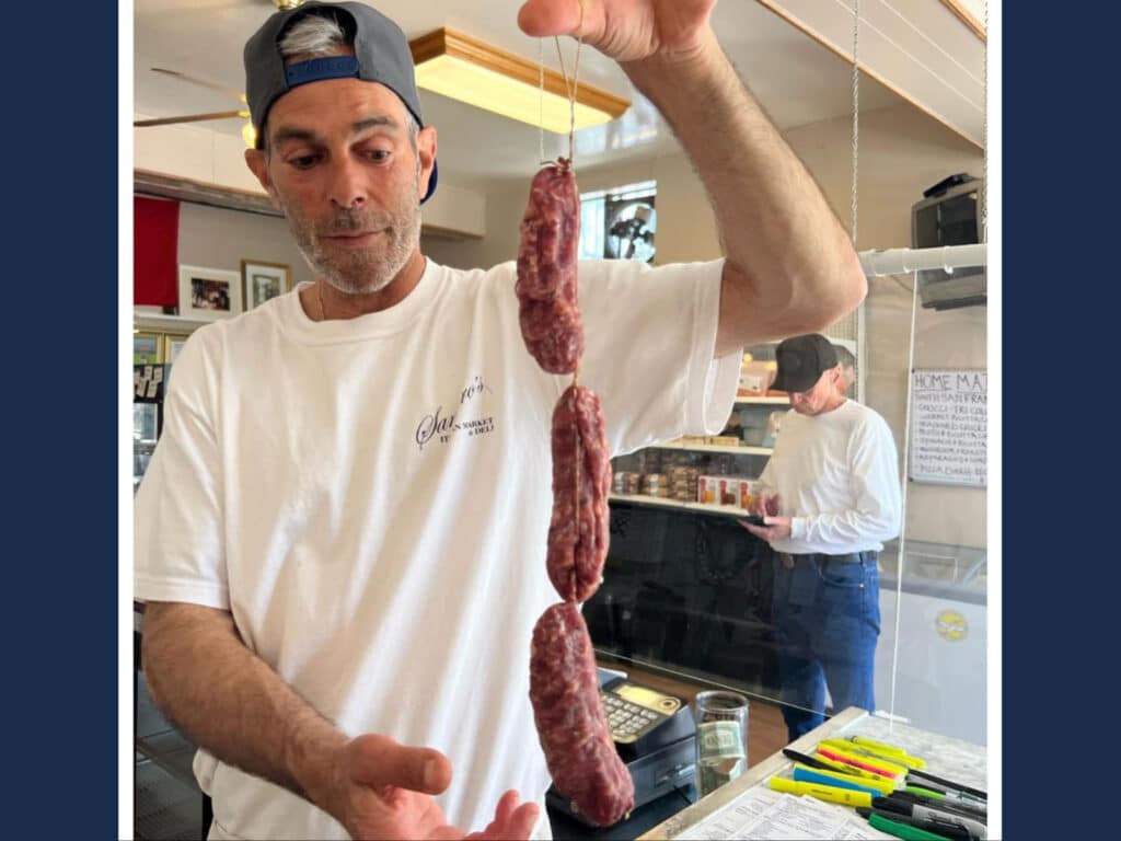 Alameda Post - Mike Santoro holds up a string of cured meats