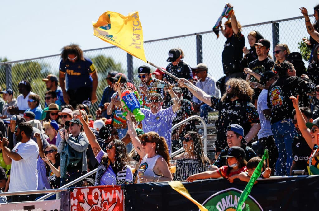 Alameda Post - an enthusiastic Oakland Soul crowd blows bubbles, waves flags, and shouts in the 7-0 game against Olympic Club