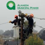 Alameda Post - Alameda Municipal Power (AMP) line workers atop a utility pole wearing orange helmets on an overcast day with the Alameda Municipal Power logo superimposed on the image.