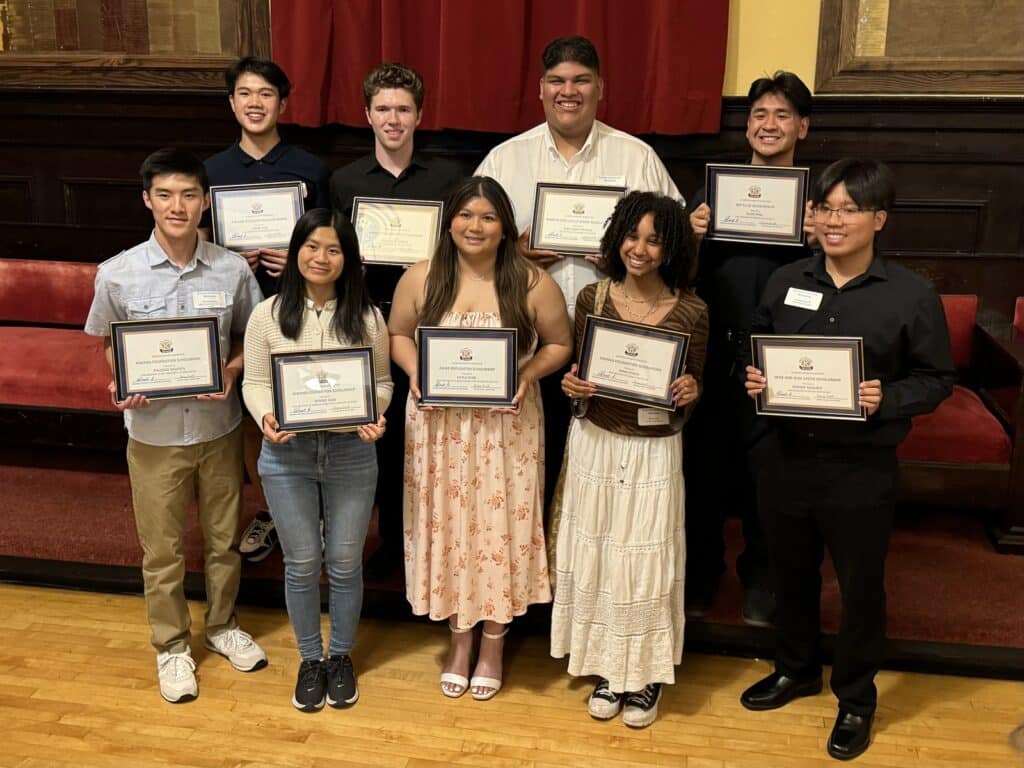 Alameda Post - Nine high school seniors pose for a photo holding framed scholarship certificates.