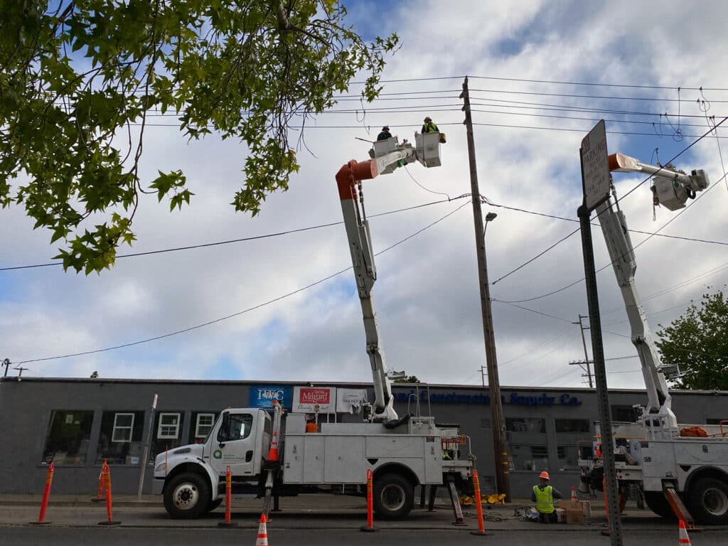 Alameda Post - Alameda Municipal Power (AMP) line workers with bucket trucks.