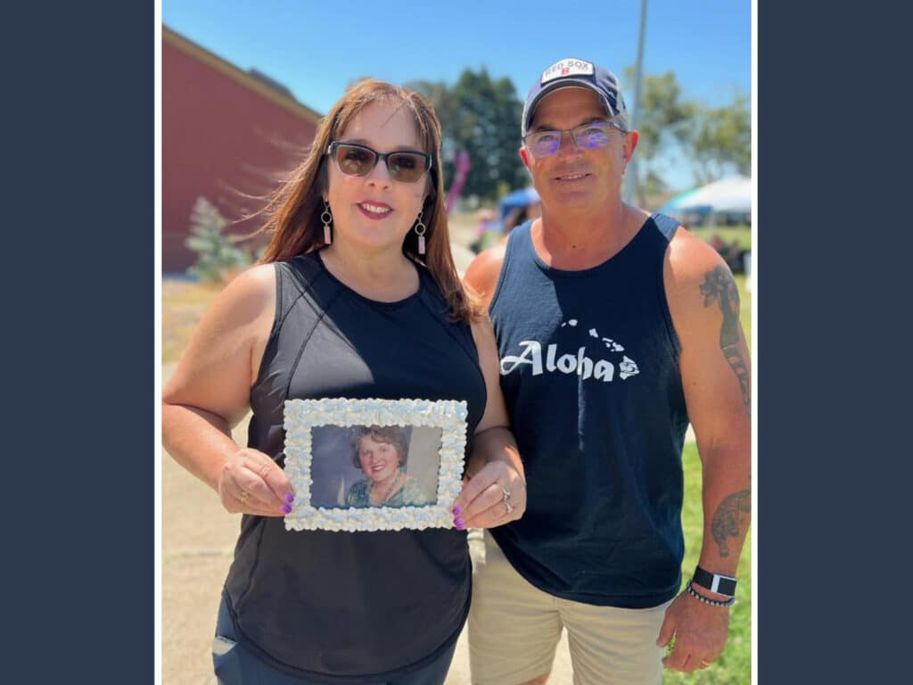 Alameda Post - Jenn and Thomas Cobb stand and hold a photo of Jenn's mother