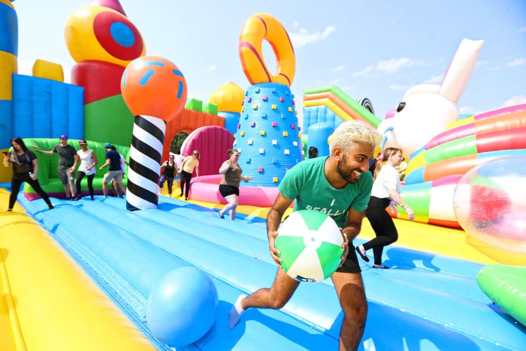 Alameda Post - adults play on a huge bounce house