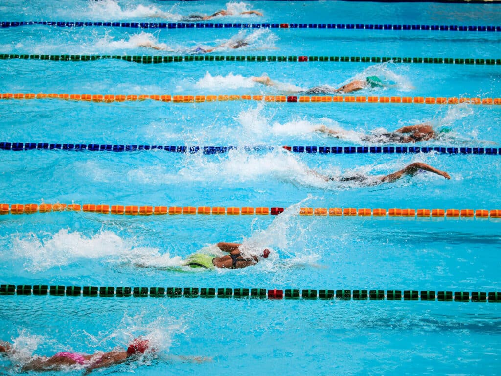 Alameda Post - a swim team in a pool swims laps