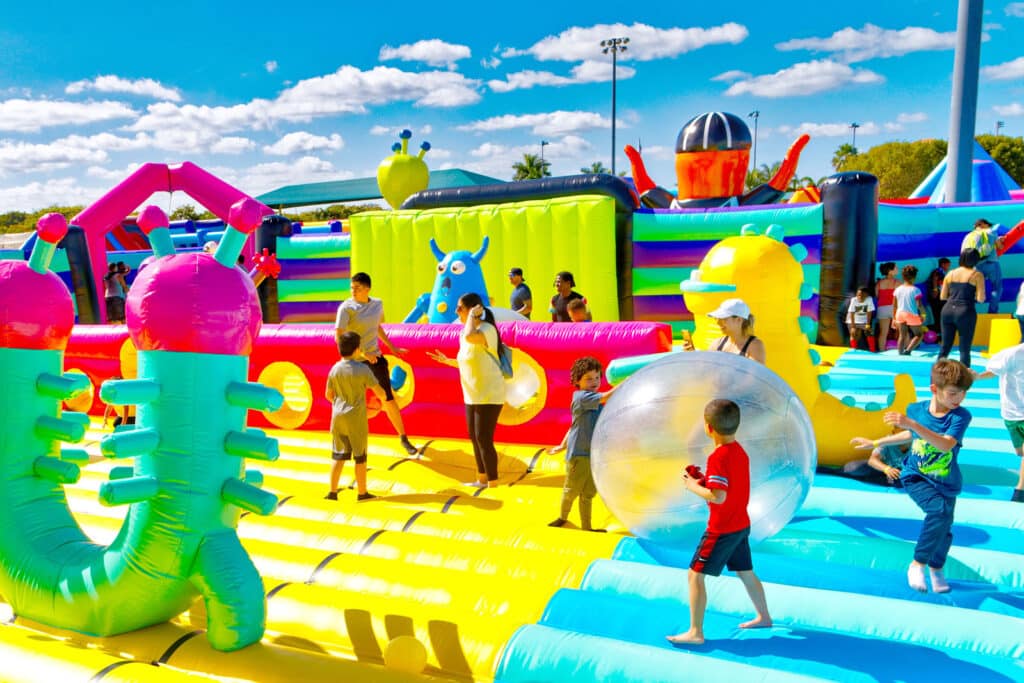 Alameda Post - children and adults play with inflated balls on a large course of a bounce house