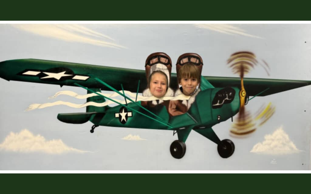 Alameda Post - a photo of two kids in a photo opportunity plane with cutouts for their heads