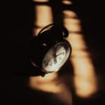 Alameda Post - an old fashioned analog alarm clock in shadows
